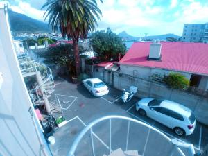 two cars parked in a parking lot next to a building at Happy Home - Woodstock in Cape Town