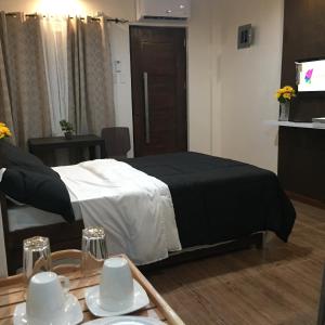 een slaapkamer met een bed en een tafel met borden bij Mirasol Residences in Daet