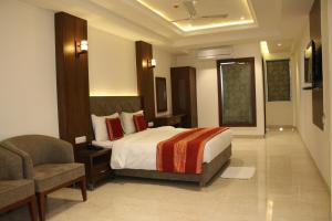 um quarto de hotel com uma cama e uma cadeira em Lavanya Hotel- Near Alipur, Delhi em Nova Deli