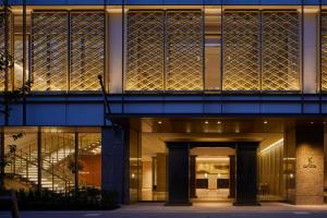 a building with a lit up facade with glass at THE KITANO HOTEL TOKYO in Tokyo
