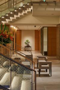 a lobby with stairs and a table and flowers at THE KITANO HOTEL TOKYO in Tokyo