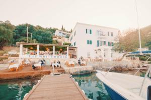 a white house with a dock and a white boat at The Durrell White House in Kalami