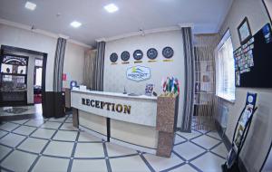 a reception counter in a store with plates on the wall at Rohat Hotel in Dushanbe