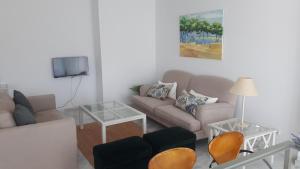 ein Wohnzimmer mit einem Sofa und einem TV in der Unterkunft Vivienda Vistahermosa Playa in El Puerto de Santa María