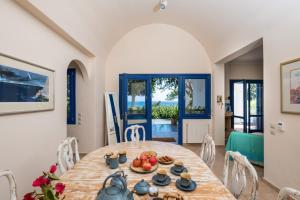a dining room with a table with food on it at Santorini Mystique Garden Villa in Kamari
