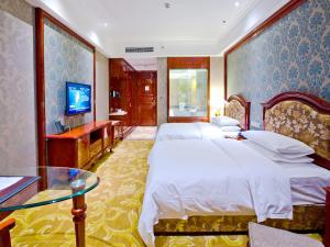 重慶市にあるフアチェン インターナショナル ホテルのベッド2台とテレビが備わるホテルルームです。