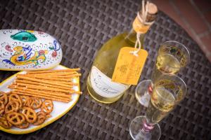 un tavolo con un piatto di pretzel e una bottiglia di vino di Na' Poesia B&B di Charme a SantʼAgata deʼ Goti