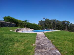 a swimming pool in the middle of a grass field at Chalet en Combarro a pie de playa in Poio