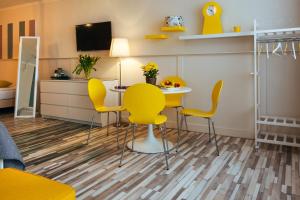 a living room with a table and yellow chairs at Hotel Corel in Scheveningen