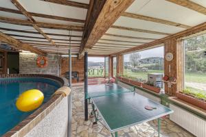 an indoor pool with a ping pong table in a house at Bauernhofpension Runenhof in Haidmühle