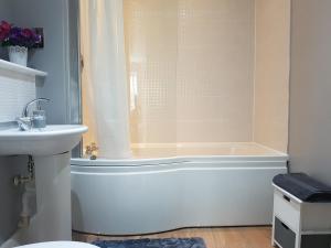 y baño con bañera y lavamanos. en 3 Bed Luxury Town Center Apartment with 50 inch 4K TV (Netflix & NowTV Ent. Pass) en Northampton