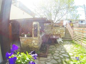 a garden with purple flowers and a stone wall at Bohemian Spirit, Vama Veche in Vama Veche