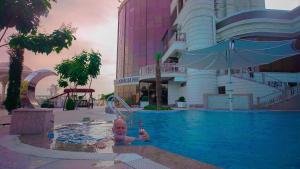 a man in a swimming pool at a hotel at Parliament Palace Hotel in Khujand