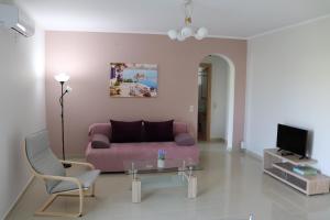 sala de estar con sofá rosa y mesa en ARIA Luxury Apartments, en Nauplia