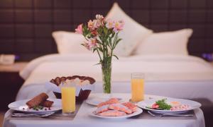 a table with two plates of food and a vase of flowers at Parliament Palace Hotel in Khujand