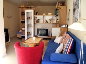 a living room with a blue couch and a tv at Jenny´s Ferienwohnungen in Bad Salzungen +15 photos