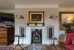 a living room with a fireplace and a tv at Church Cottage in Bath