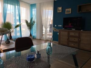a living room with a tv and a vase on a table at Azur Apartment Deluxe in Chernomorets