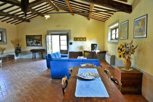 a living room with a blue couch and a table at Villa Conte Gualtiero in Sarteano