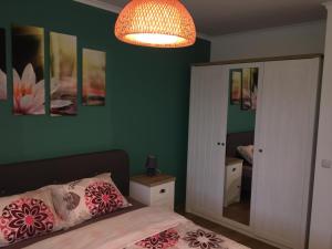 a bedroom with green walls and a bed and a chandelier at Azur Apartment Deluxe in Chernomorets +11 photos