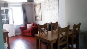 a living room with a table and a red couch at Archie's Rest in Drumshanbo