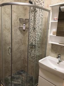 een badkamer met een douche en een wastafel bij Azur Apartment Deluxe in Chernomorets