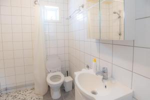 a white bathroom with a toilet and a sink at Fjelltun 6-sengs in Trysil