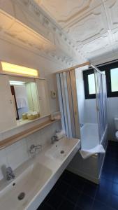 a bathroom with a sink, mirror and bath tub at Hotel Garni Tiziana in Losone