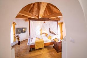 a bedroom with a canopy bed and a wooden floor at Residence Safari Resort - Chateau in Borovany
