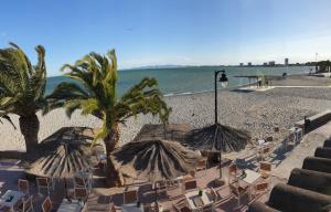 uma praia com cadeiras e guarda-sóis e o oceano em Apartamento Playa Lo Pagán em Lo Pagán