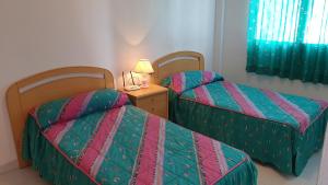 una camera con due letti e un tavolo con una lampada di Apartamento Playa Lo Pagán a Lo Pagán