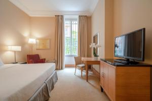 a hotel room with a bed and a flat screen tv at Hotel Capo d´África – Colosseo in Rome