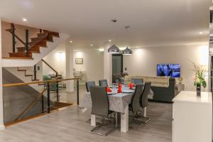 Un comedor y una sala de estar con mesa y sillas. en A&M House II Luxury Holidays Home, en Arco da Calheta