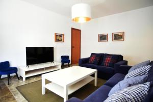sala de estar con sofá azul y TV en Casa Bel, en Sant Carles de la Ràpita