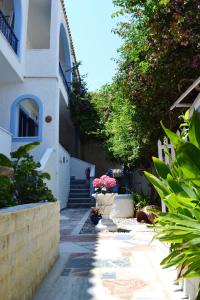 a path leading to a building with flowers and plants at Koralli Studios in Korissia