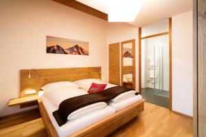 a bedroom with a large bed with a wooden headboard at AlpinLodges Matrei in Matrei in Osttirol