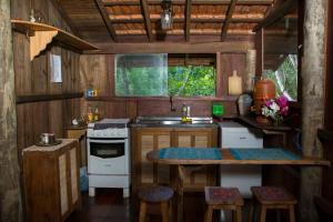a small kitchen with a table and a stove at Chalé Candeia no Matutu in Aiuruoca
