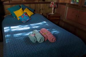 duas bonecas deitadas numa cama num quarto em Chalé Candeia no Matutu em Aiuruoca