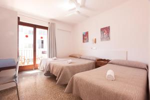 a hotel room with two beds and a balcony at Hostal Las Nieves in Ibiza Town +124 photos