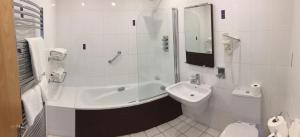 a bathroom with a sink and a tub and a toilet at Carlingford Marina Apartments in Carlingford