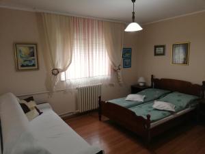 een slaapkamer met 2 bedden en een raam bij Guest House Major in Arandjelovac