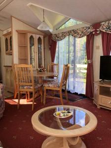 a living room with a table and chairs and a tv at Lyndhurst in Dunoon