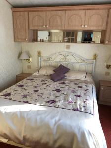 a bedroom with a large white bed with flowers on it at Lyndhurst in Dunoon