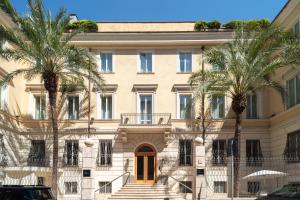 a building with palm trees in front of it at Hotel Capo d´África – Colosseo in Rome