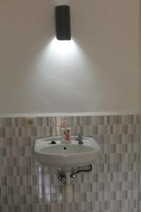 un bagno con lavandino e luce sopra di EJA GUEST HOUSE a Ende