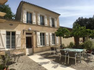 una casa con una mesa y sillas frente a ella en Domaine de Ludeye en Listrac-Médoc