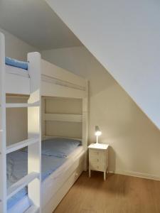 1 dormitorio con 2 literas y mesa con lámpara en Marschküken, en Wrixum