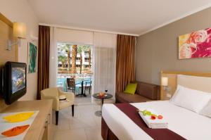 a hotel room with a bed and a living room at Leonardo Royal Resort Eilat in Eilat