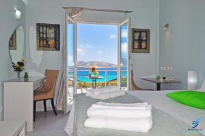 1 dormitorio con cama y vistas al océano en Myrto Hotel, en Koufonisia