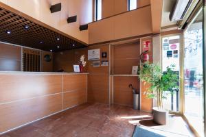 a lobby with a counter and a potted plant at Hotel Real in Lleida